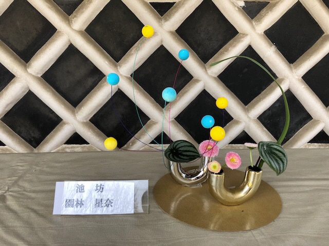 画像ファイル：「生け花展:Uの字の花器に水色と黄色の玉のオブジェを生けた作品の写真」の詳細を見る