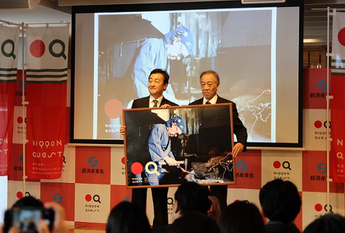 日本刀作刀」の写真パネルを持つ松永源六郎氏ニッポンクエストアワード受賞の様子の写真