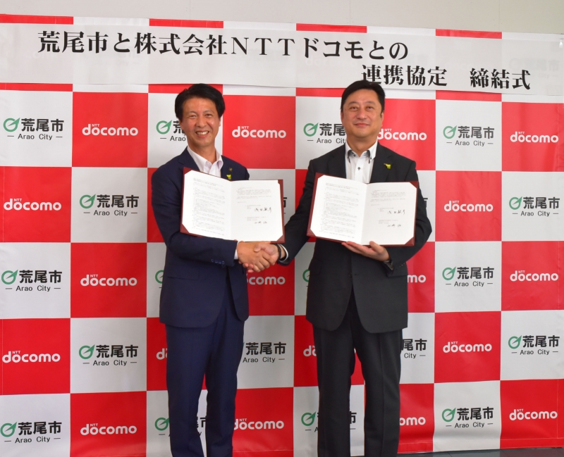 株式会社NTTドコモとの連携協定締結式の男性2人の写真